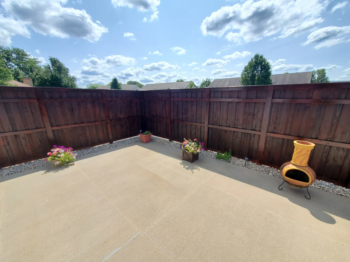 Dark stained wood privacy fence around a patio